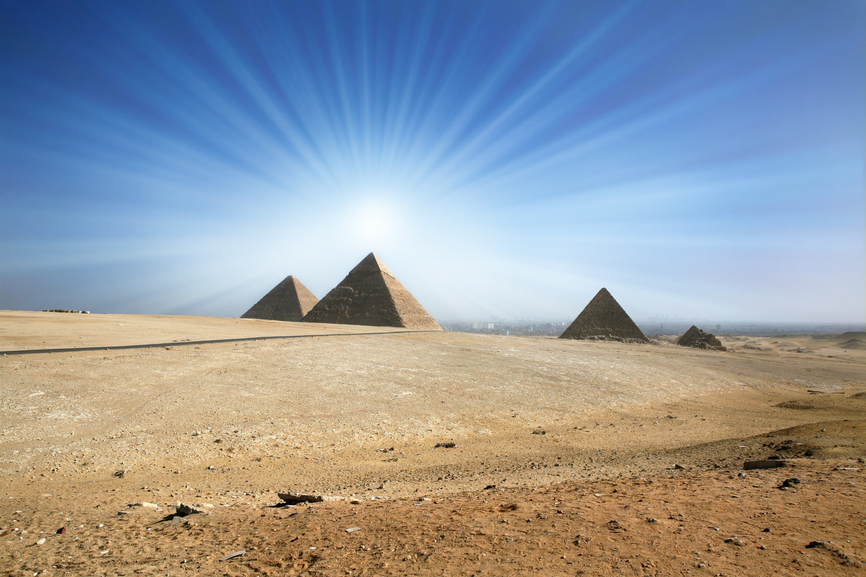 Light of the sun in the sky over an ancient pyramid.