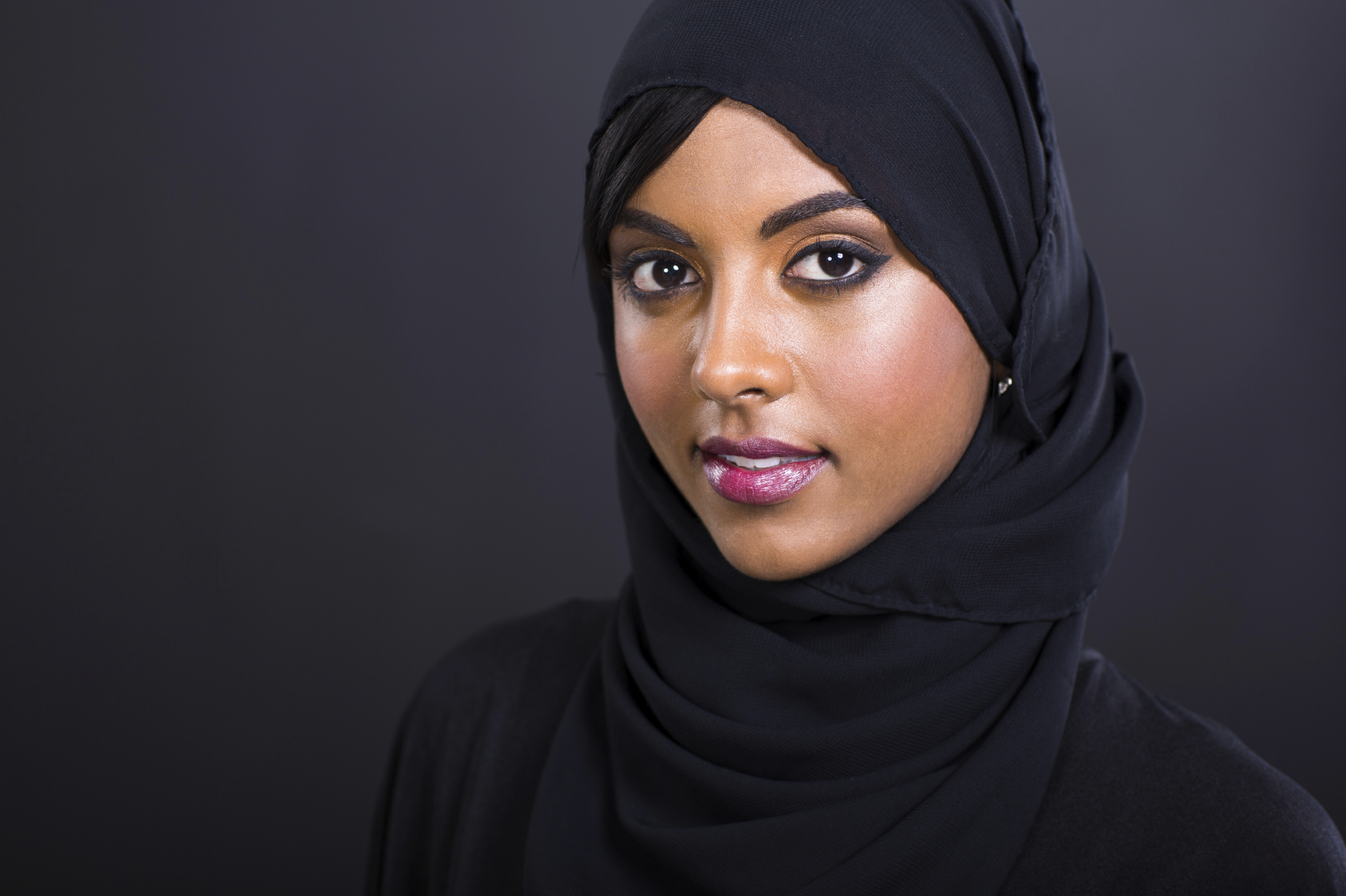 pretty young muslim woman head shot over black background